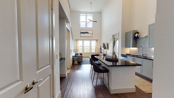 Interior of apartment facing the kitchen, living room, and large interior windows from the entry door. - Photo Gallery 92