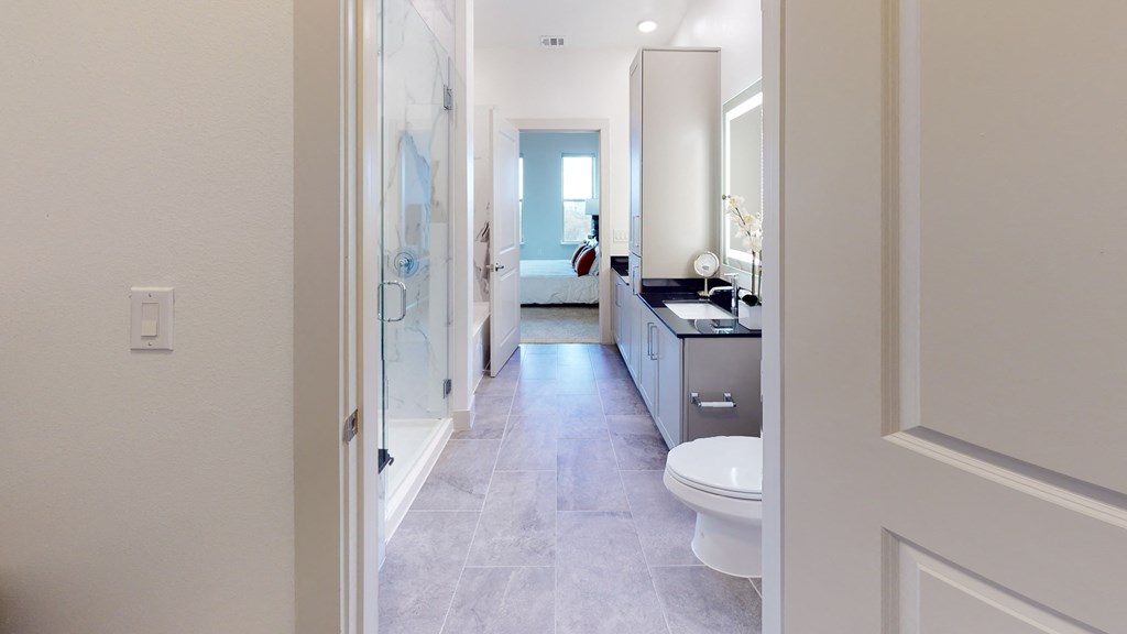 Interior of bathroom facing stand-in shower and sink from the closet