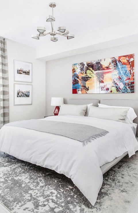 A bedroom with a large bed and a chandelier.
