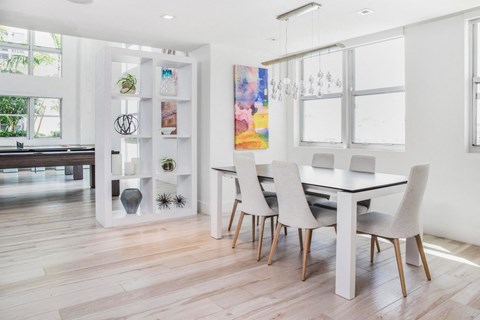 A dining room with a white table and chairs.