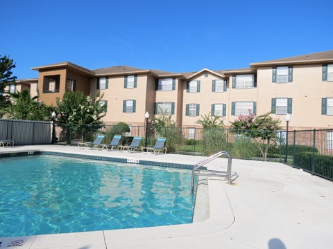 A swimming pool in front of apartment buildings.
