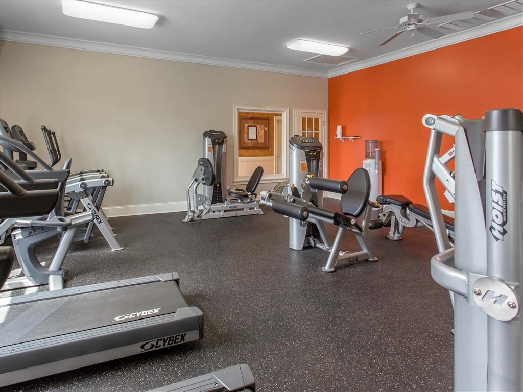 Fitness Center with Exercise Equipment with Orange and Mirror Accent Wall
