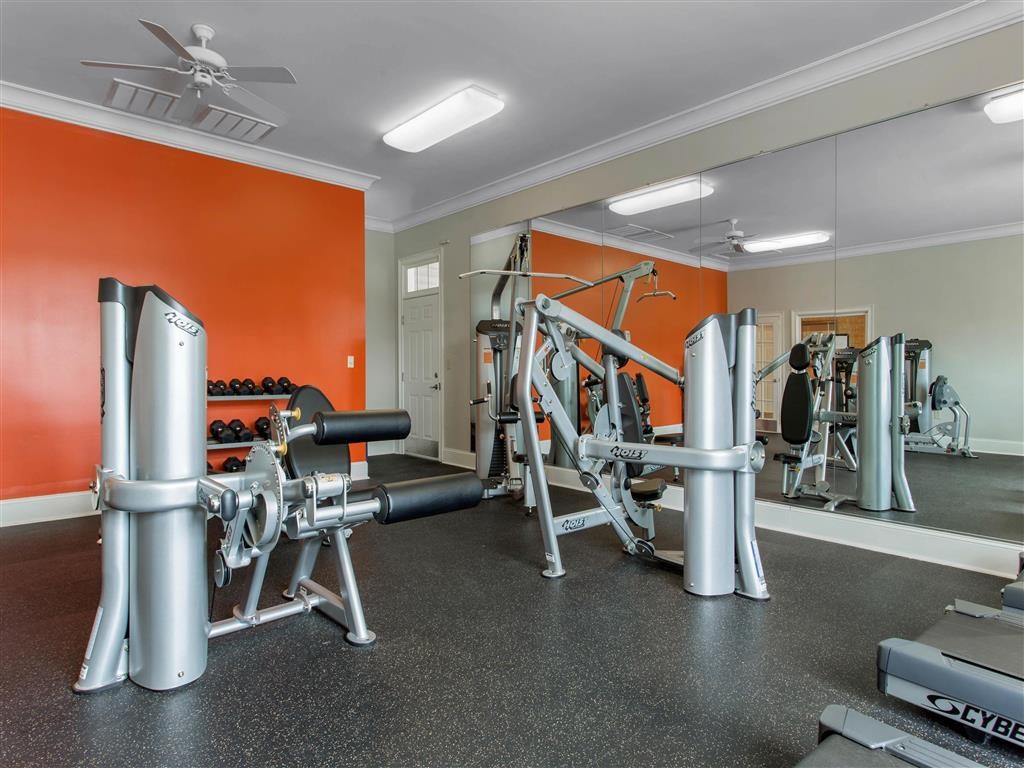 Fitness Center with Exercise Equipment with Orange and Mirror Accent Wall