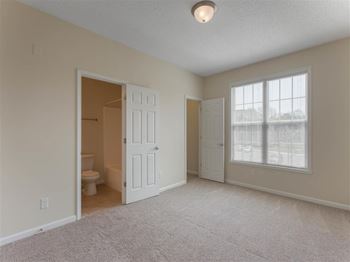 Carpeted Bedroom with Large Window En-Suite Bathroom and Walk-in Closet