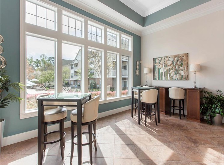 Clubhouse Seating Area with Bar Height Tables and Stools in Front of Large WIndows