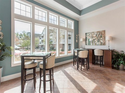 Clubhouse Seating Area with Bar Height Tables and Stools in Front of  Large WIndows
