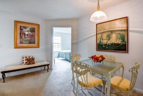 Decorated Carpeted Model Dining Room with Table and Chairs