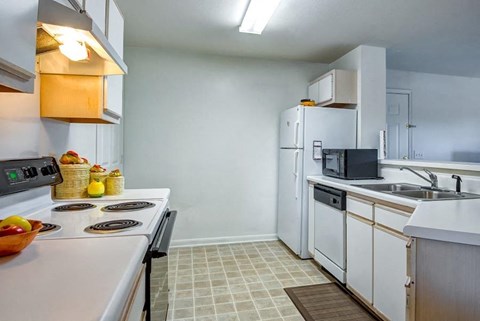 A kitchen with white appliances and a white counter top.
