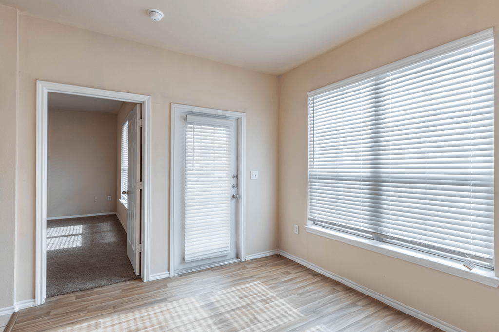a living room with two large windows and a door to the patio
