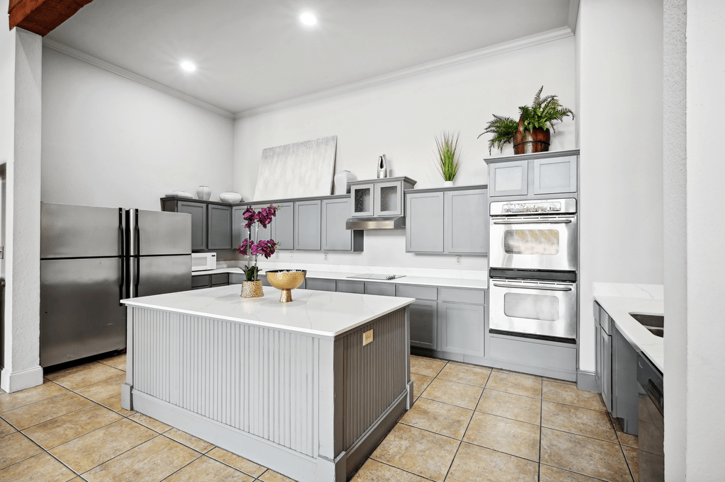 a large kitchen with stainless steel appliances and a white counter top