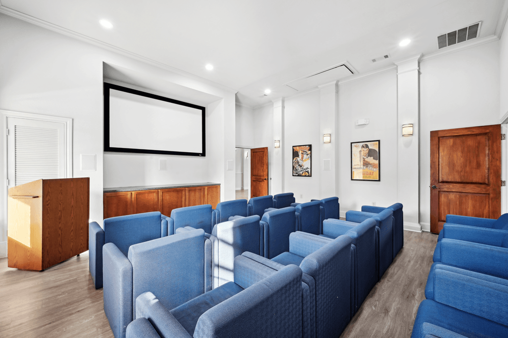 a conference room with blue couches and a projector