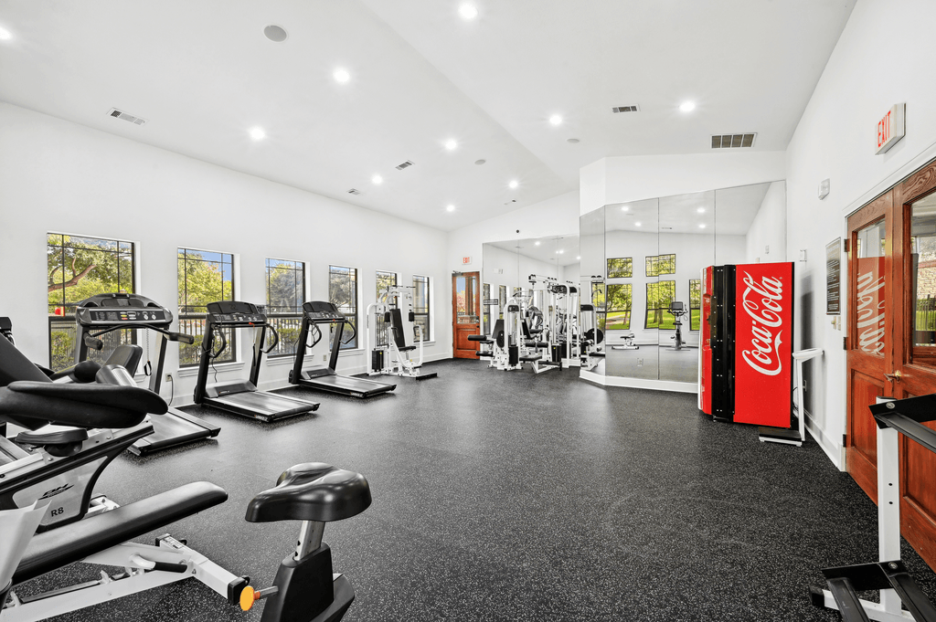 the gym with cardio machines and other exercise equipment at the belgard apartments
