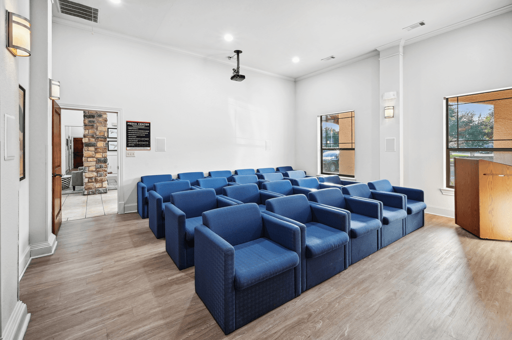 a conference room with blue chairs and a wood floor
