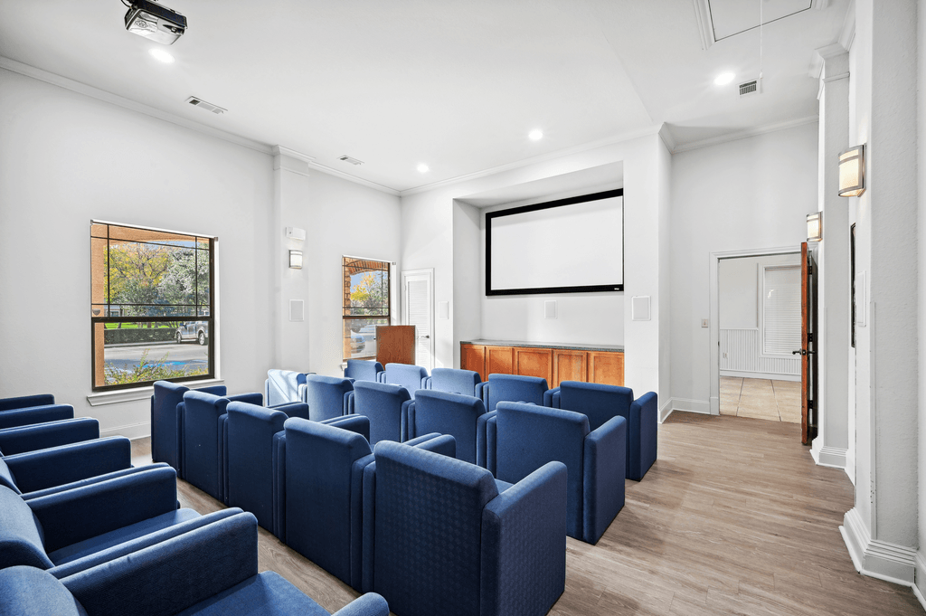 a conference room with blue chairs and a projector
