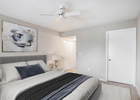 a bedroom with a bed and a ceiling fan