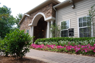a house with a walkway and flowers in front of it