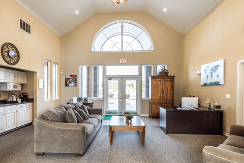 A living room with a grey couch and a wooden coffee table.