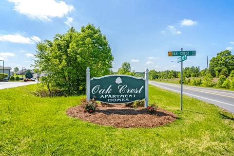 a sign for oak creek apartments with a street sign in front of it