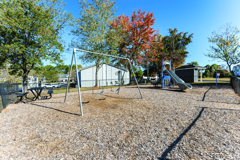 A playground with a swing set and a slide.
