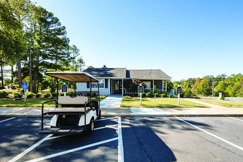 A golf cart is parked in a parking spot in front of a building.