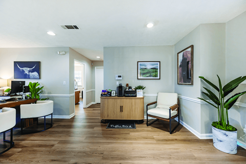 A reception area with a wooden desk and a white chair.
