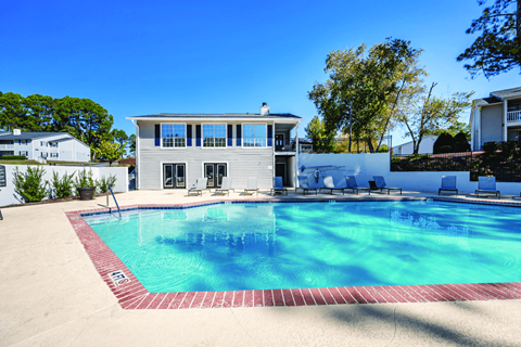 A swimming pool in front of a house.