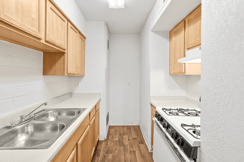 A kitchen with wooden cabinets and a stainless steel sink.