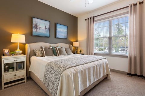 A bedroom with a large bed and two lamps.