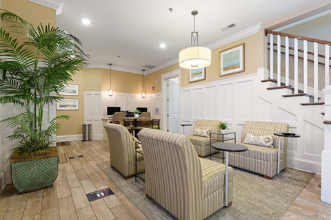 A living room with a striped couch and a wooden floor.