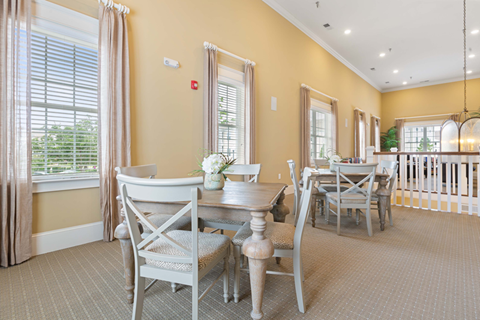 A dining room with a table set for four.