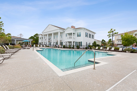 A large white house with a pool in front.