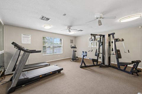 A gym with treadmills, elliptical machines, and other exercise equipment.