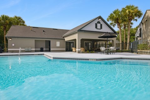 A house with a pool in front of it.
