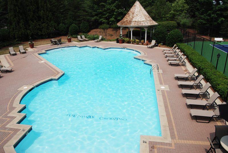 a large swimming pool with chairs and a gazebo