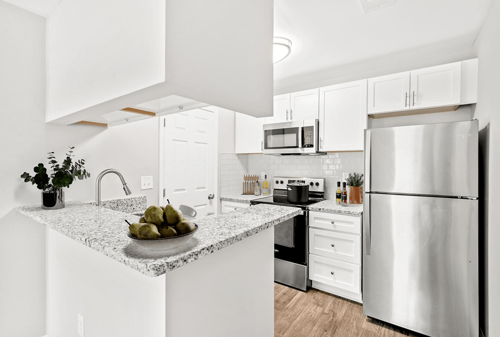 A modern kitchen with a granite countertop and stainless steel appliances at Paces Pointe Apartment Homes, Matthews, NC