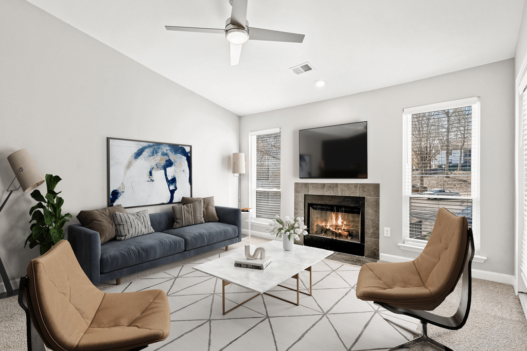 A living room with a fireplace and a painting of a woman at Paces Pointe Apartment Homes, Matthews, NC