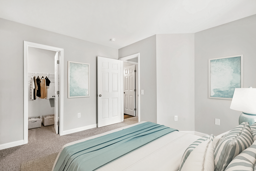 A bedroom with a large bed and a painting on the wall at Paces Pointe Apartment Homes, North Carolina