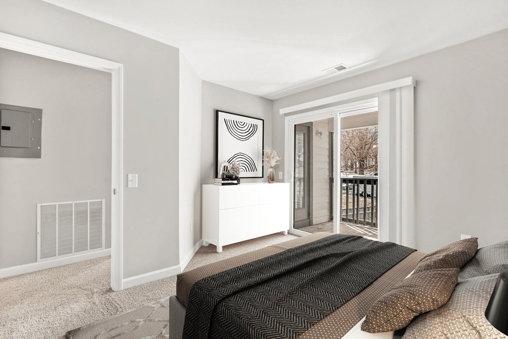 A bedroom with a bed, a dresser, and a window at Paces Pointe Apartment Homes, Matthews