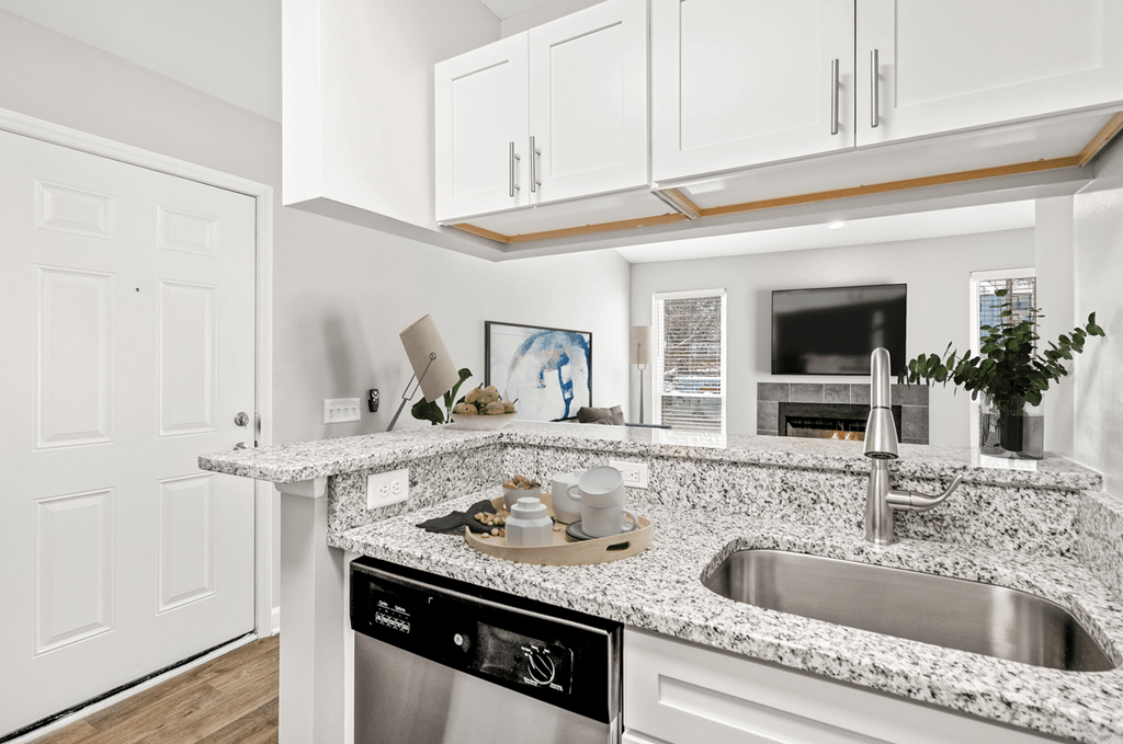 A modern kitchen with a granite countertop and stainless steel appliances at Paces Pointe Apartment Homes, Matthews, 28105