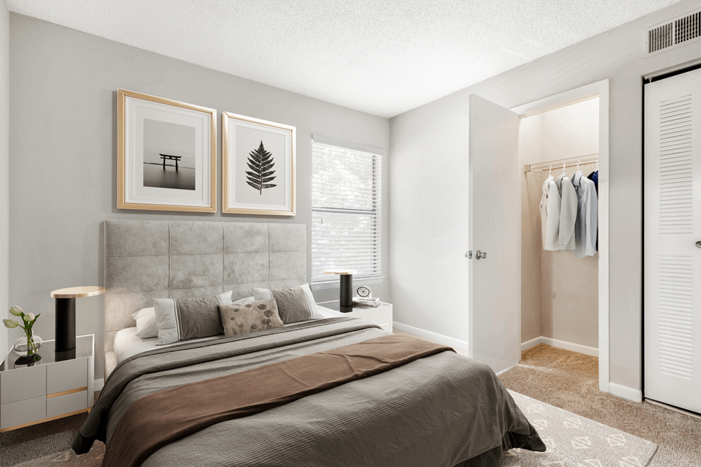 A bedroom with a large bed and two picture frames on the wall at Paces Pointe Apartment Homes, Matthews, North Carolina