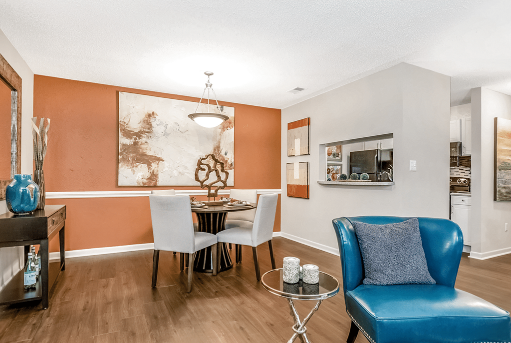 A blue leather chair sits in a room with orange walls at Paces Pointe Apartment Homes, Matthews