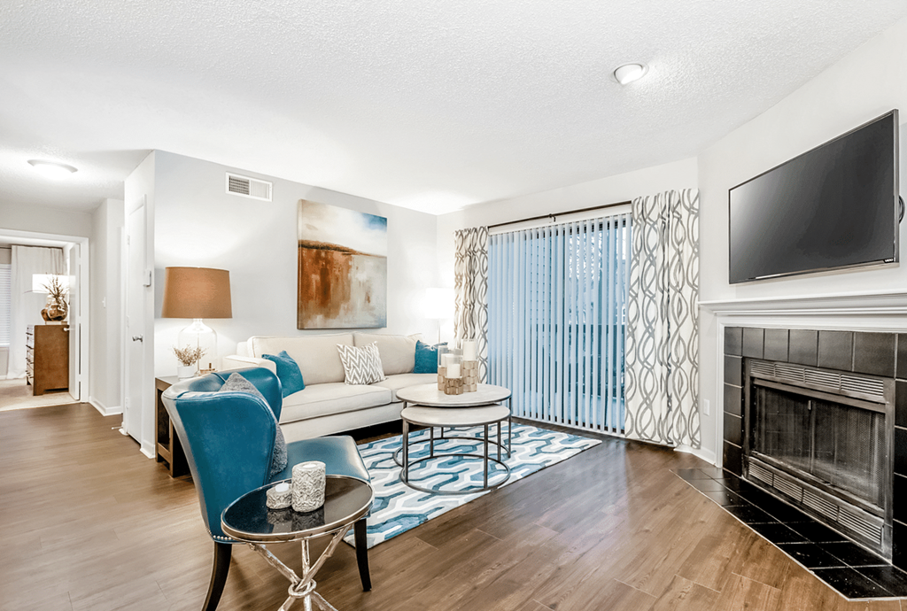 A living room with a blue chair and a fireplace at Paces Pointe Apartment Homes, Matthews, 28105