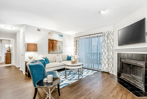 A living room with a blue chair and a fireplace.