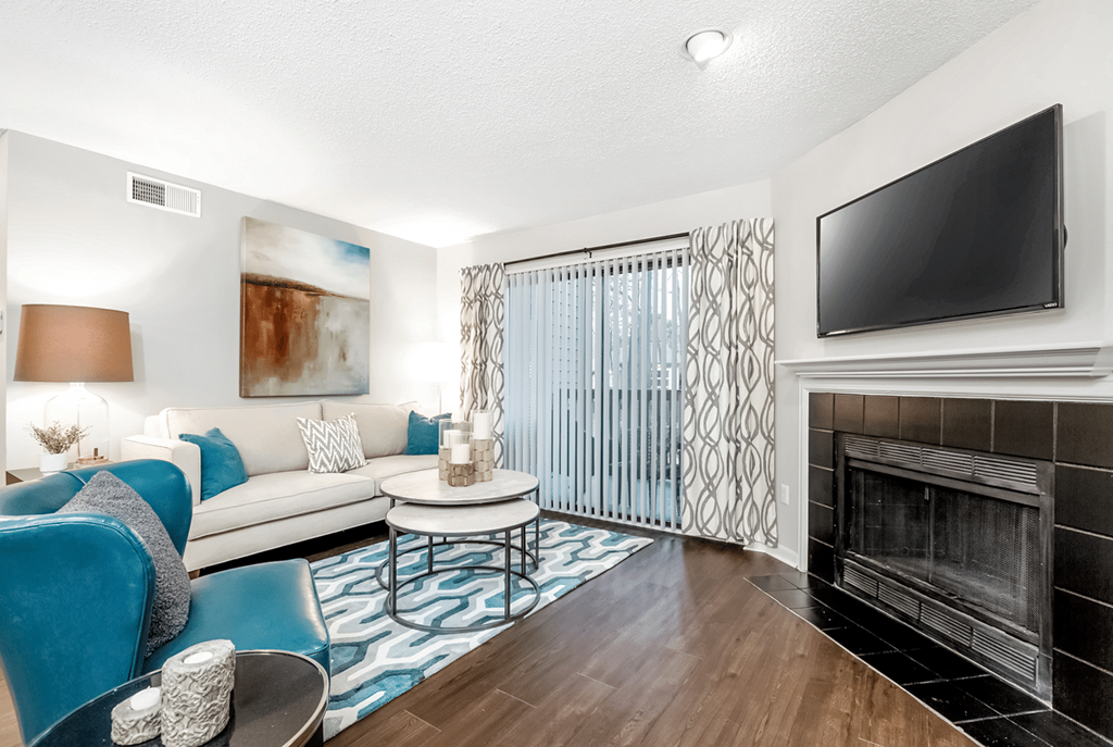 A living room with a fireplace and a television at Paces Pointe Apartment Homes, Matthews, North Carolina
