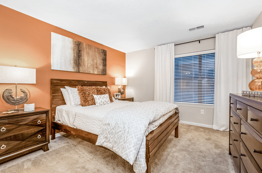 A bedroom with a bed, nightstand, and dresser at Paces Pointe Apartment Homes, Matthews, North Carolina