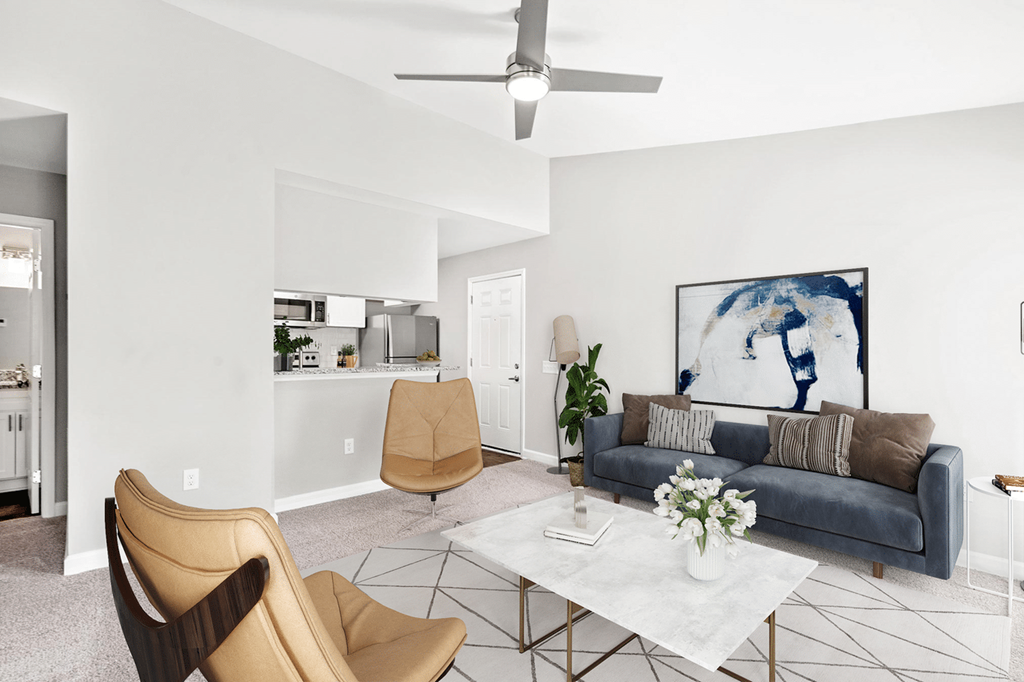 A living room with a grey couch, a coffee table, and a painting on the wall at Paces Pointe Apartment Homes, Matthews, North Carolina