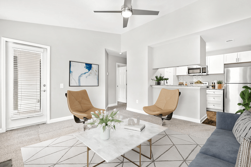 A modern living room with a white coffee table and two chairs at Paces Pointe Apartment Homes, Matthews, NC, 28105