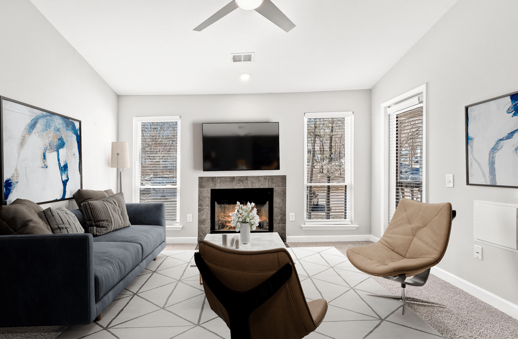 A living room with a fireplace, a chair, and a couch at Paces Pointe Apartment Homes, Matthews, NC