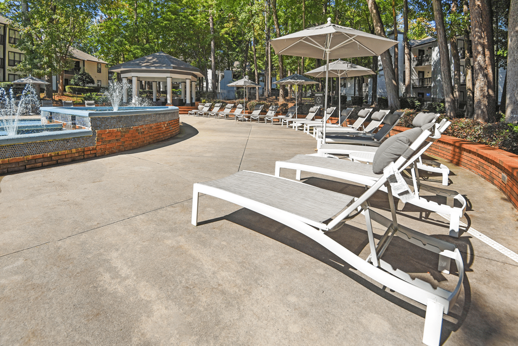 A row of sun loungers are arranged in a row in a sunny courtyard at Paces Pointe Apartment Homes, Matthews, NC