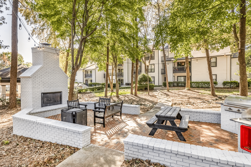 A patio with a fireplace and seating area at Paces Pointe Apartment Homes, Matthews, NC